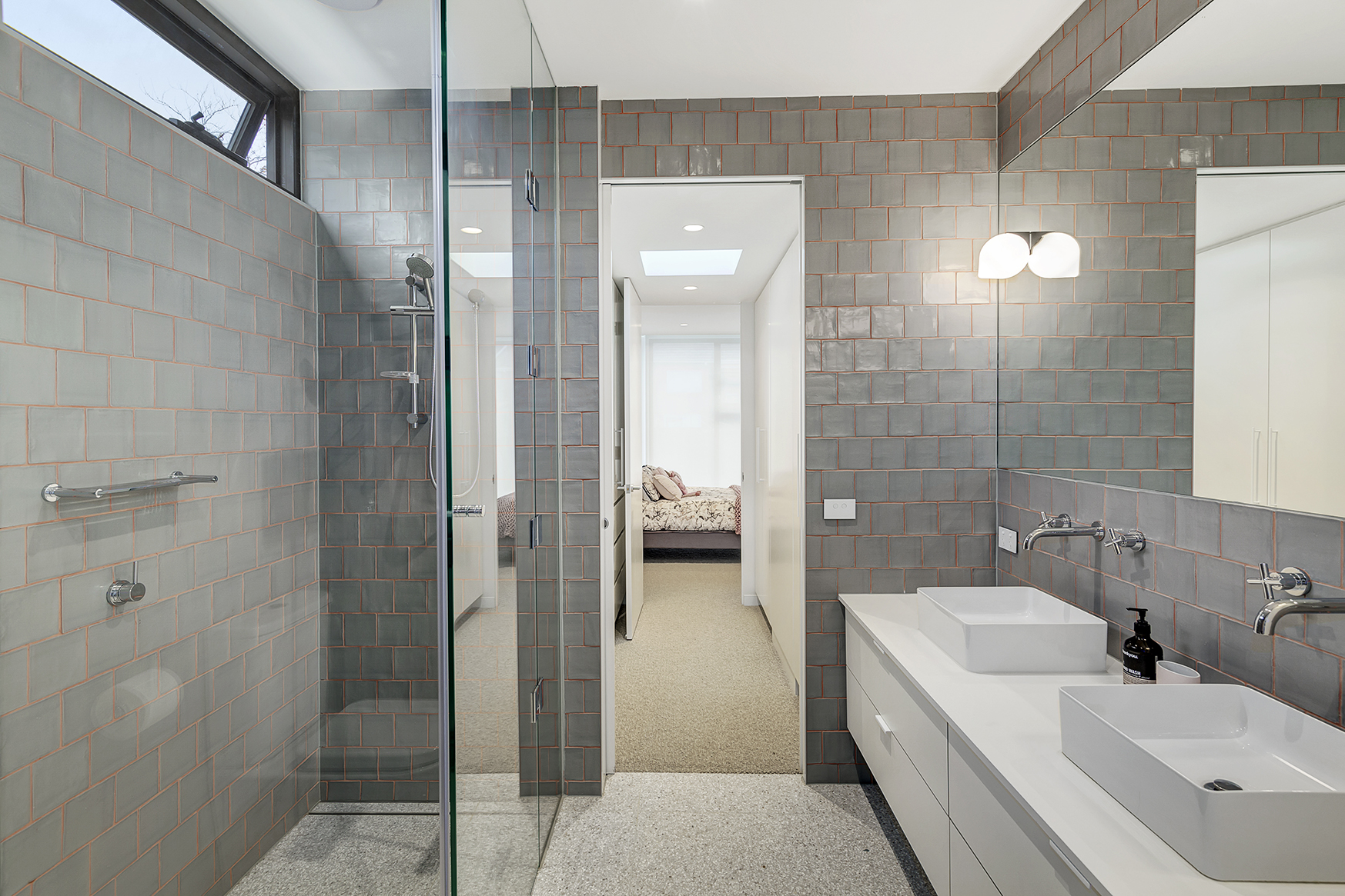 Reconfigured bathroom layout with custom vanity and lighting