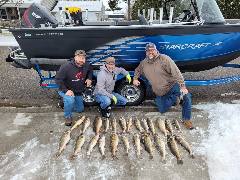 A licensed captain and a veteran reeling in a fish on Lake Michigan