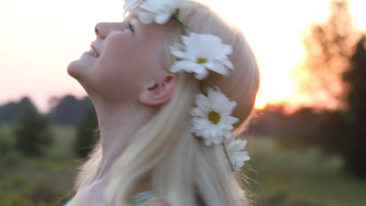 A young girl in a field at golden hour