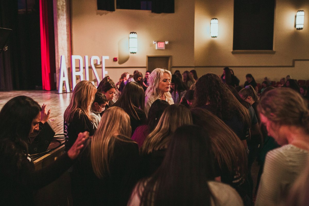 Jennifer praying with girls at an ARISE event