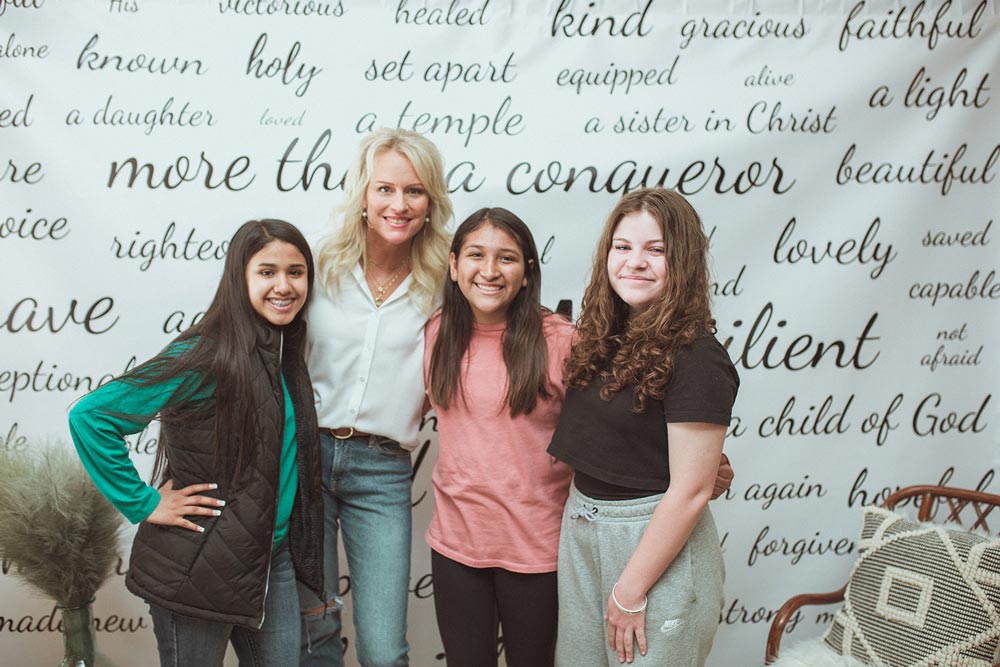 Jennifer with young women at the identity wall