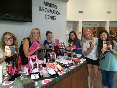 Young women holding Jennifer's books at a ministry event