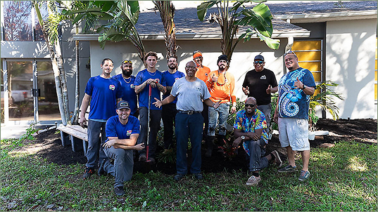 A commercial landscaping team in Indian Rocks Beach, posing for a group picture in front of a recently completed project.