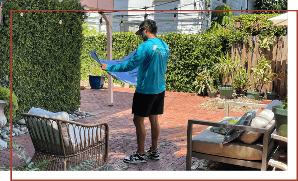 Backyard landscaping project in Tampa Bay with a landscaper on a brick patio.