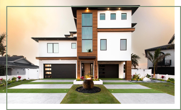 Modern Hawaiian home exterior in Redington Beach with a rock garden and paver driveway.