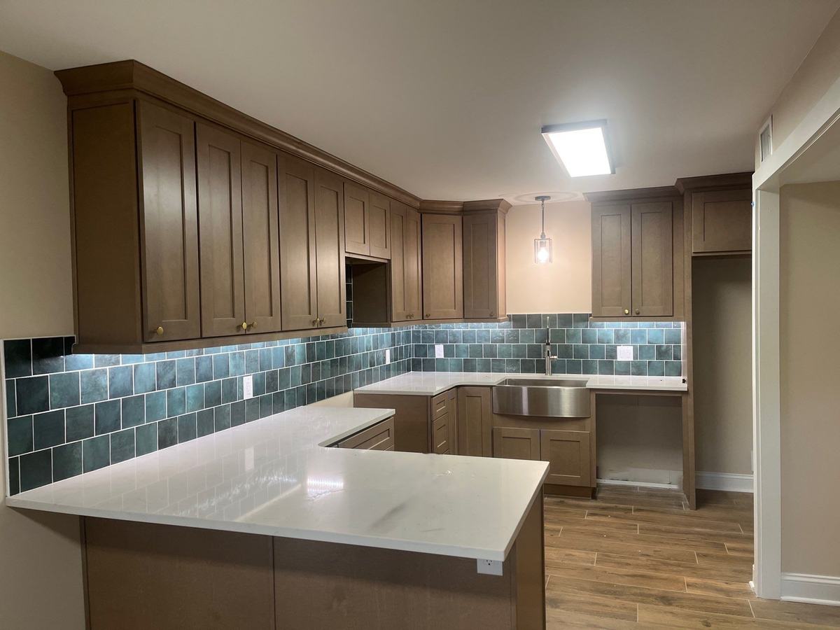 Stained shaker kitchen with quartz countertops and blue tile backsplash