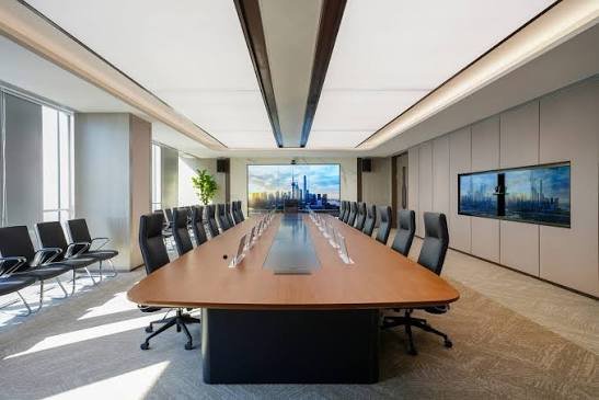 Sunon board room with long wood table, high-back chairs and display screens