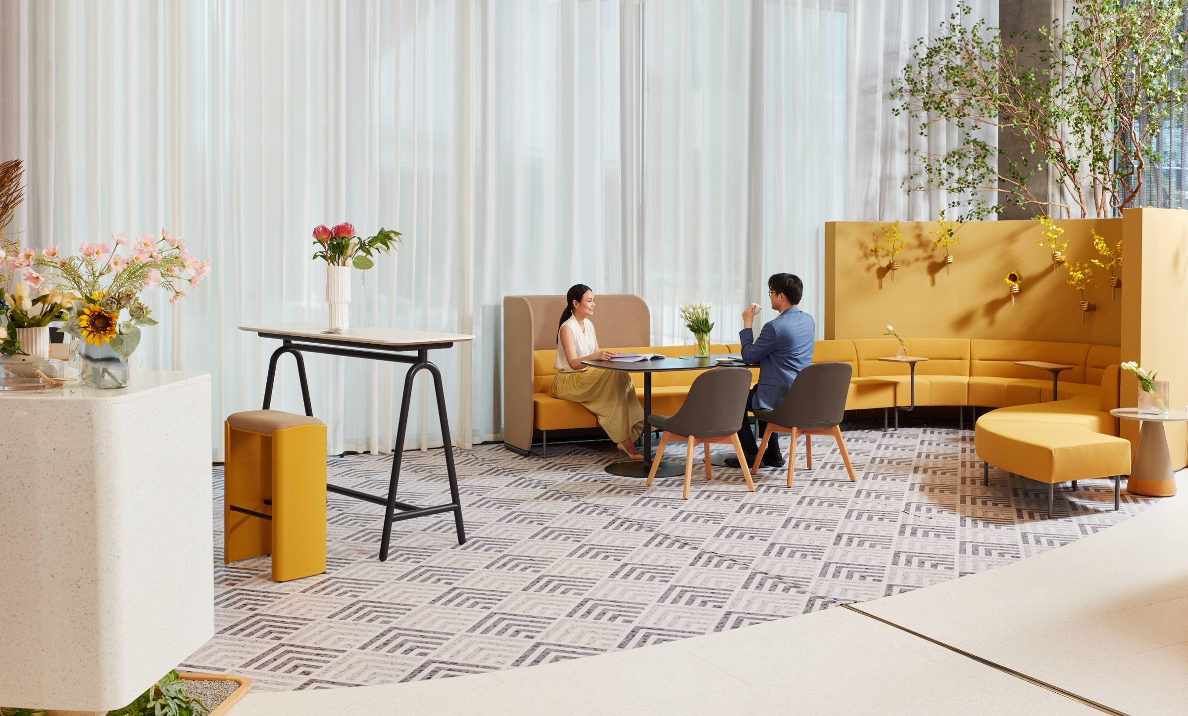 Sunon meeting area with curved yellow banquette, high-back booth, café table and bar-height table