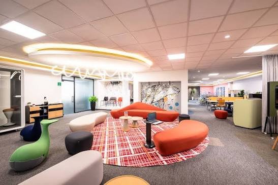 Sunon lounge with curved orange sofas, ottomans and casual seating