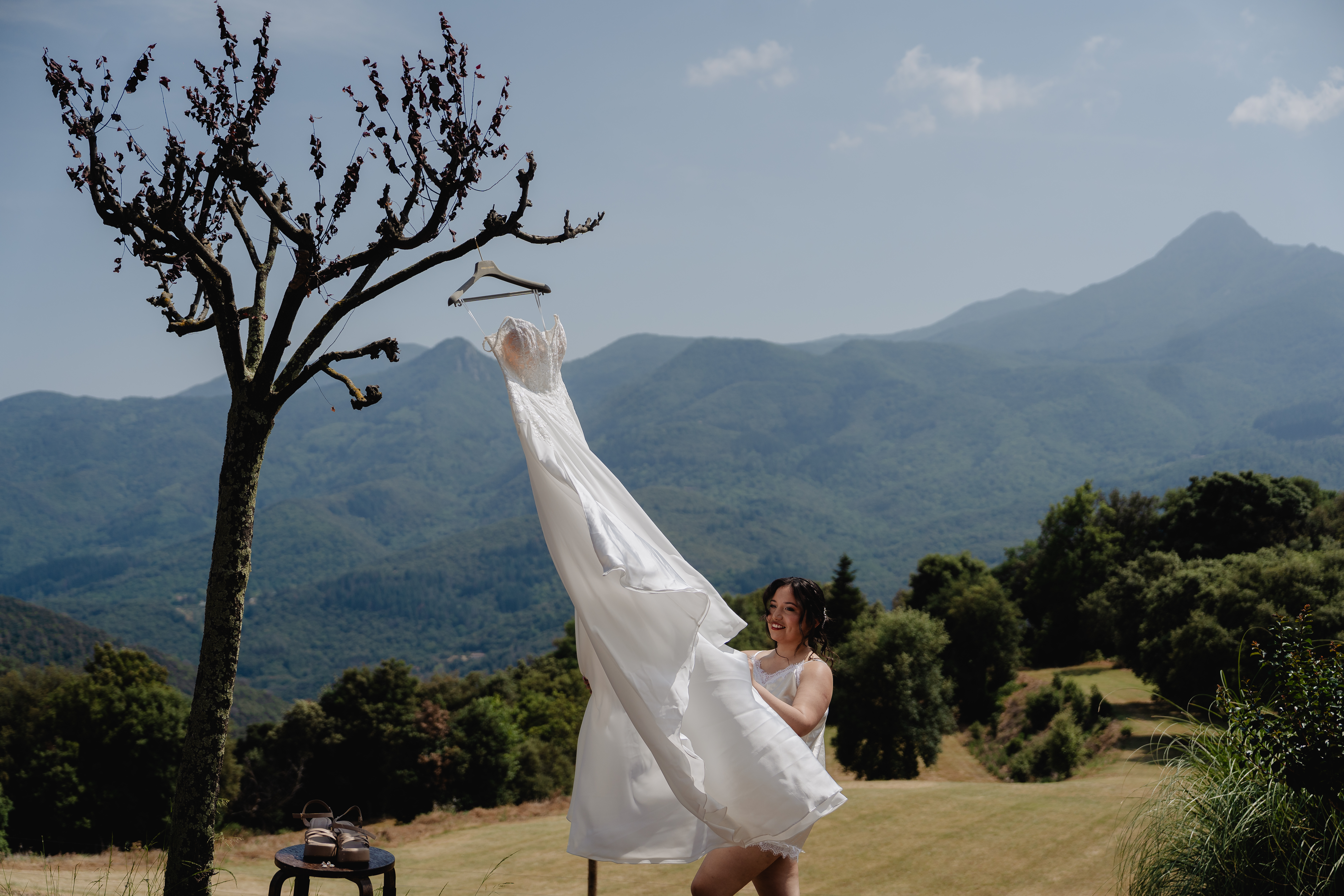 La novia toca su vestido colgado de un árbol