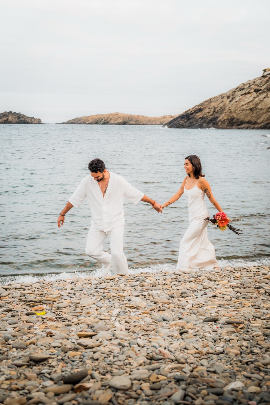 Suso y Marieta caminando de la mano por la orilla de una playa