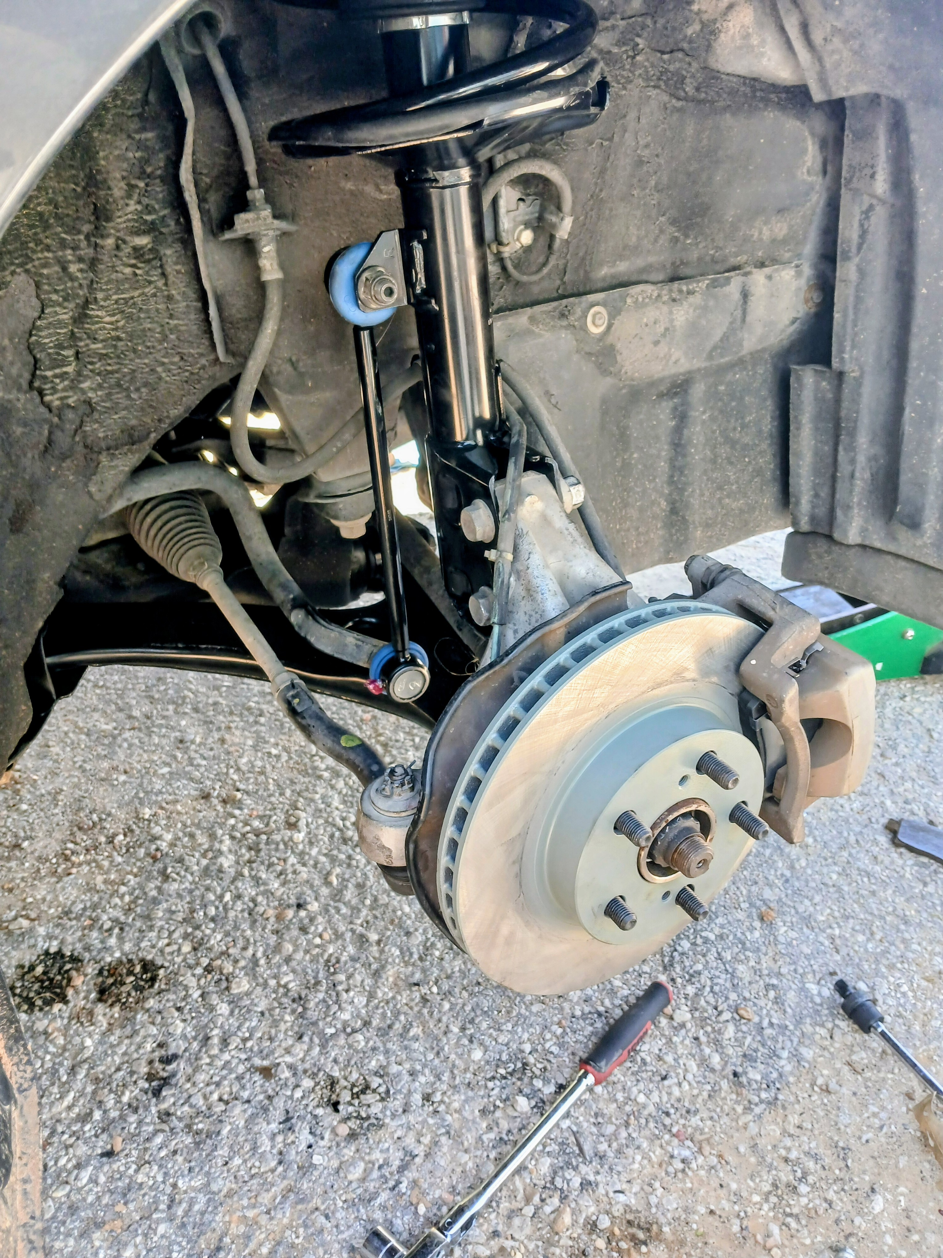New brake rotor and caliper installed during mobile brake service in Bastrop, TX