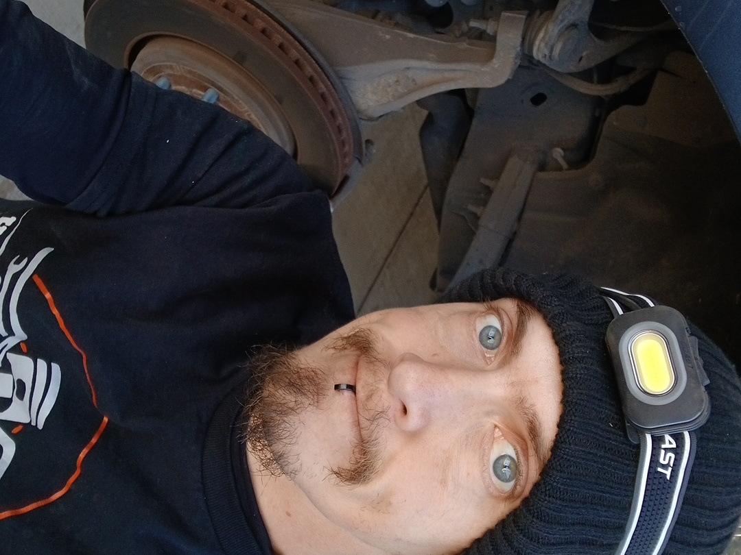 Joe Davenport, owner and mobile mechanic at Honest Joe's Auto, working under a vehicle in Bastrop County, TX