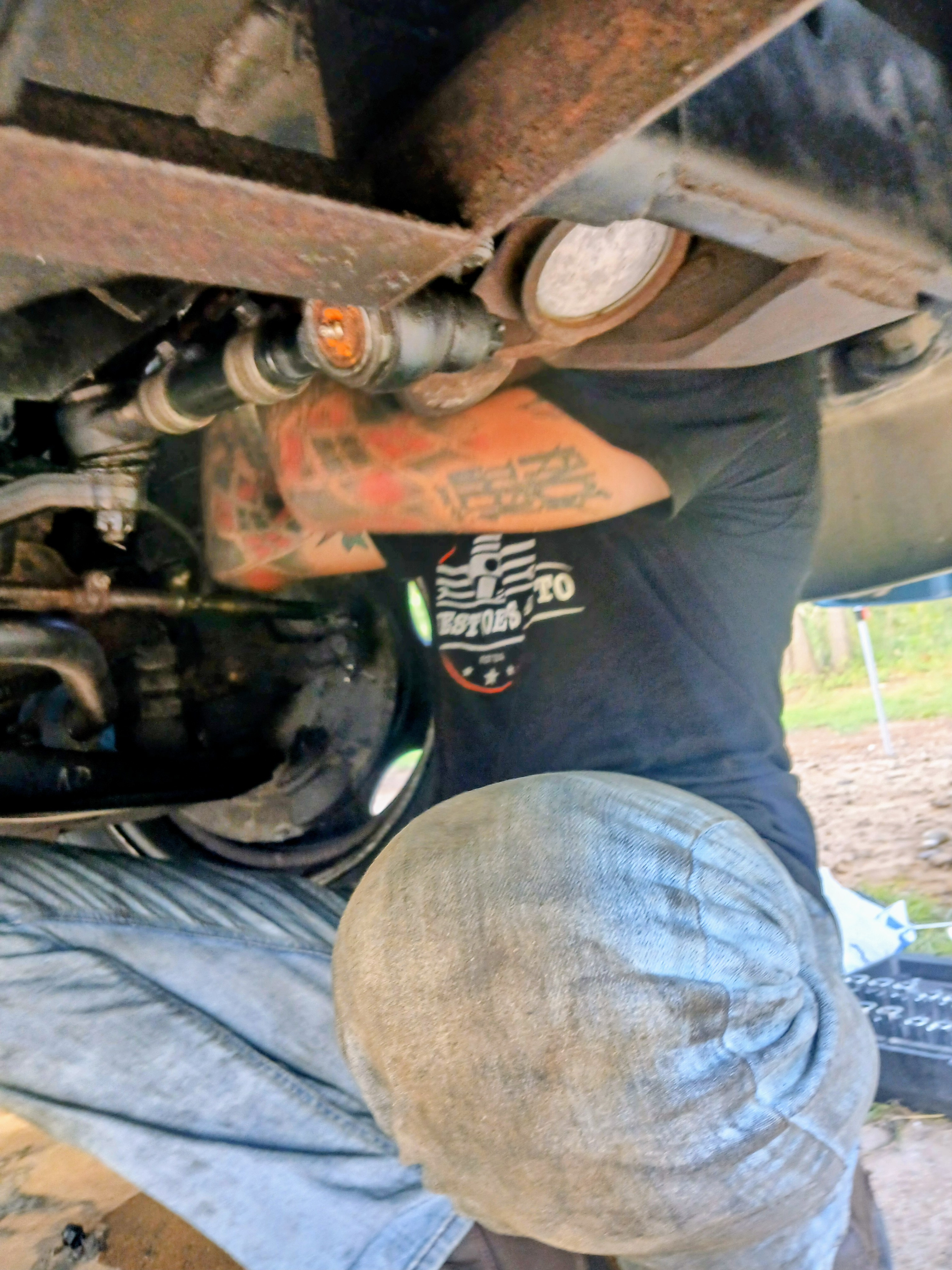Joe Davenport working underneath a truck on-site at a rural property in Bastrop County, TX