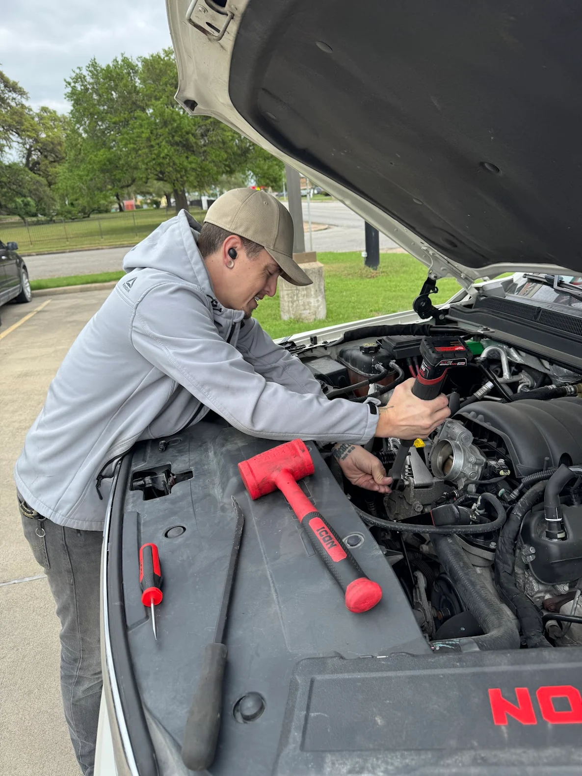 Joe Davenport, mobile mechanic at Honest Joe's Auto, performing on-site engine repair in Bastrop County, TX