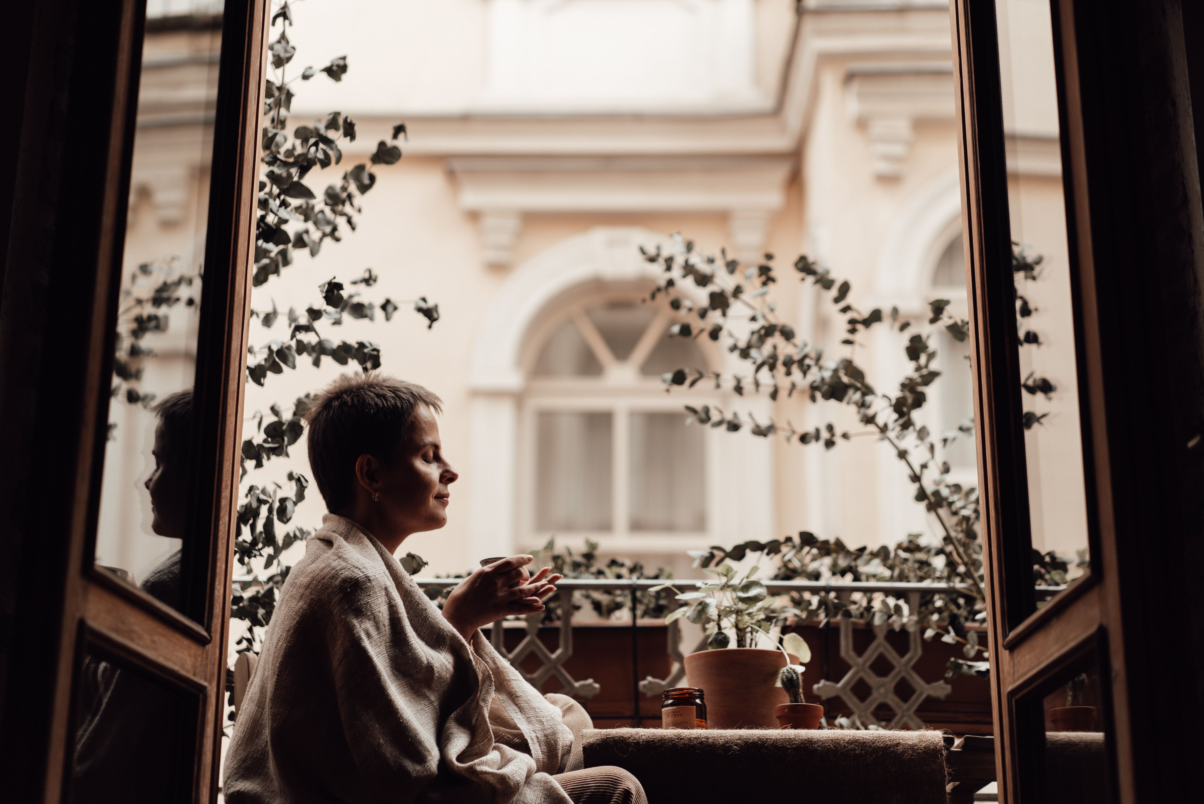 Woman journaling in the morning light, coffee beside her