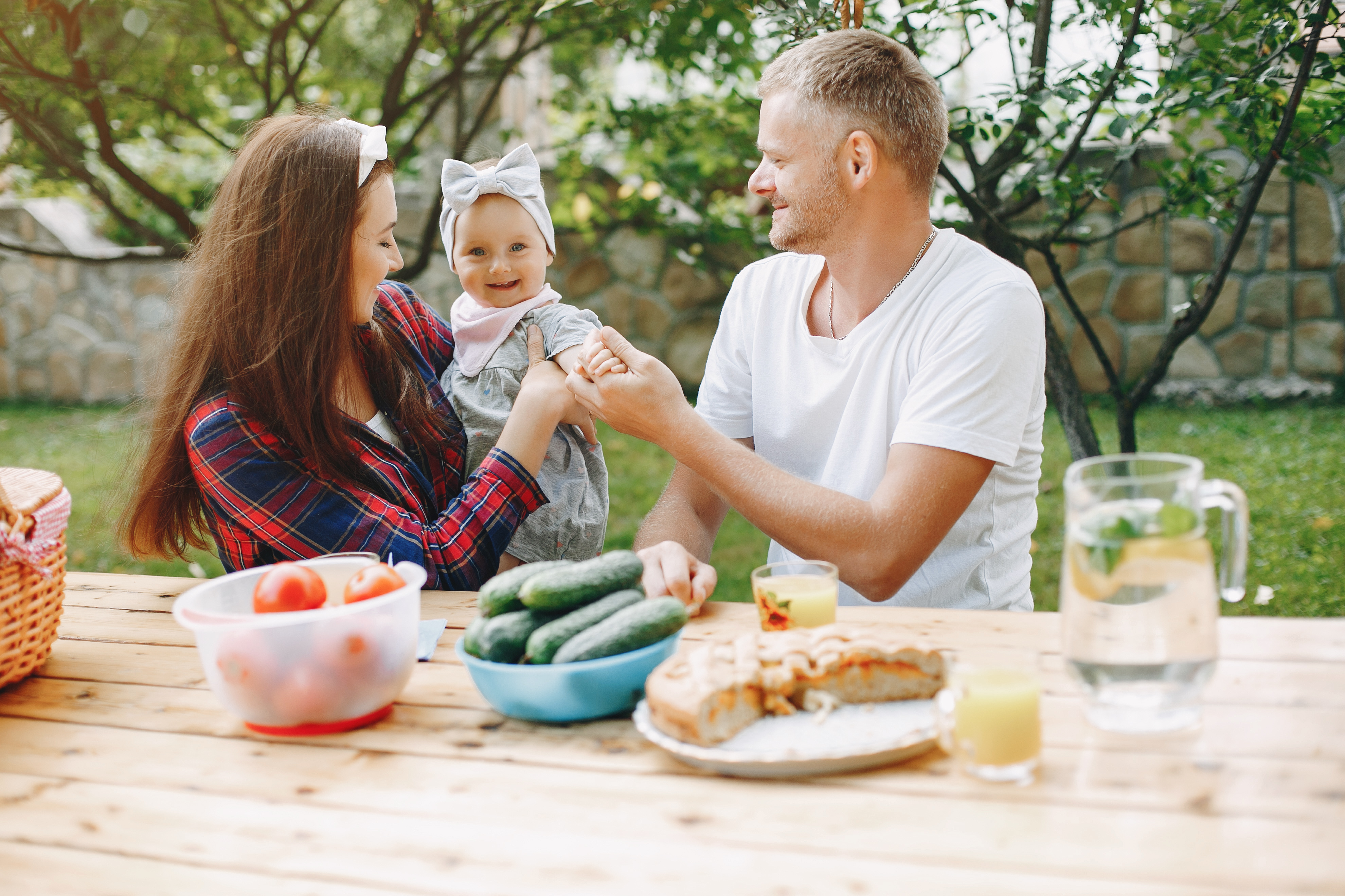 Familia con niños pequeños desayunando juntos al aire libre en verano manteniendo la rutina
