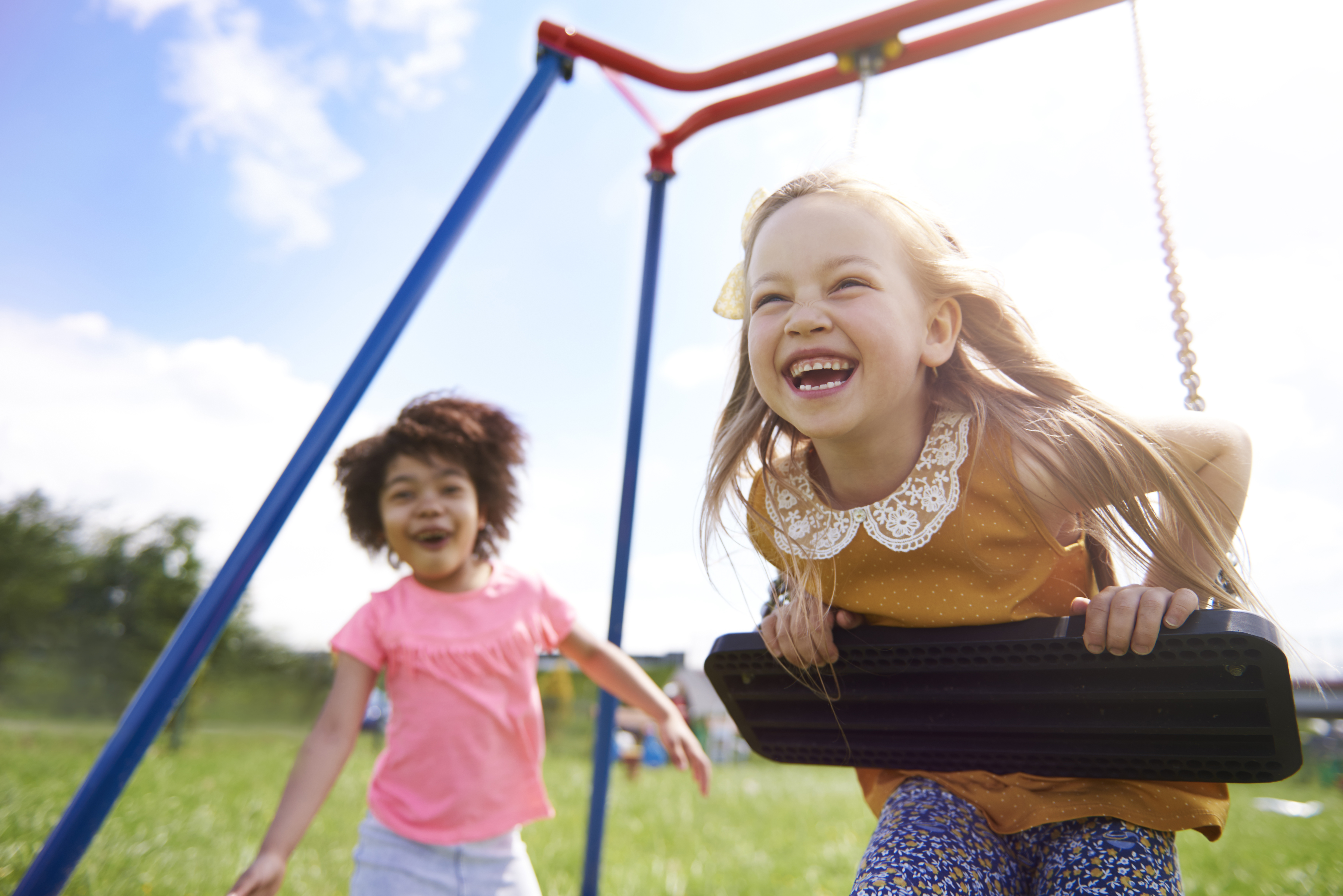 Niños de infantil jugando libremente en el jardín durante el verano, expresiones de alegría y bienestar