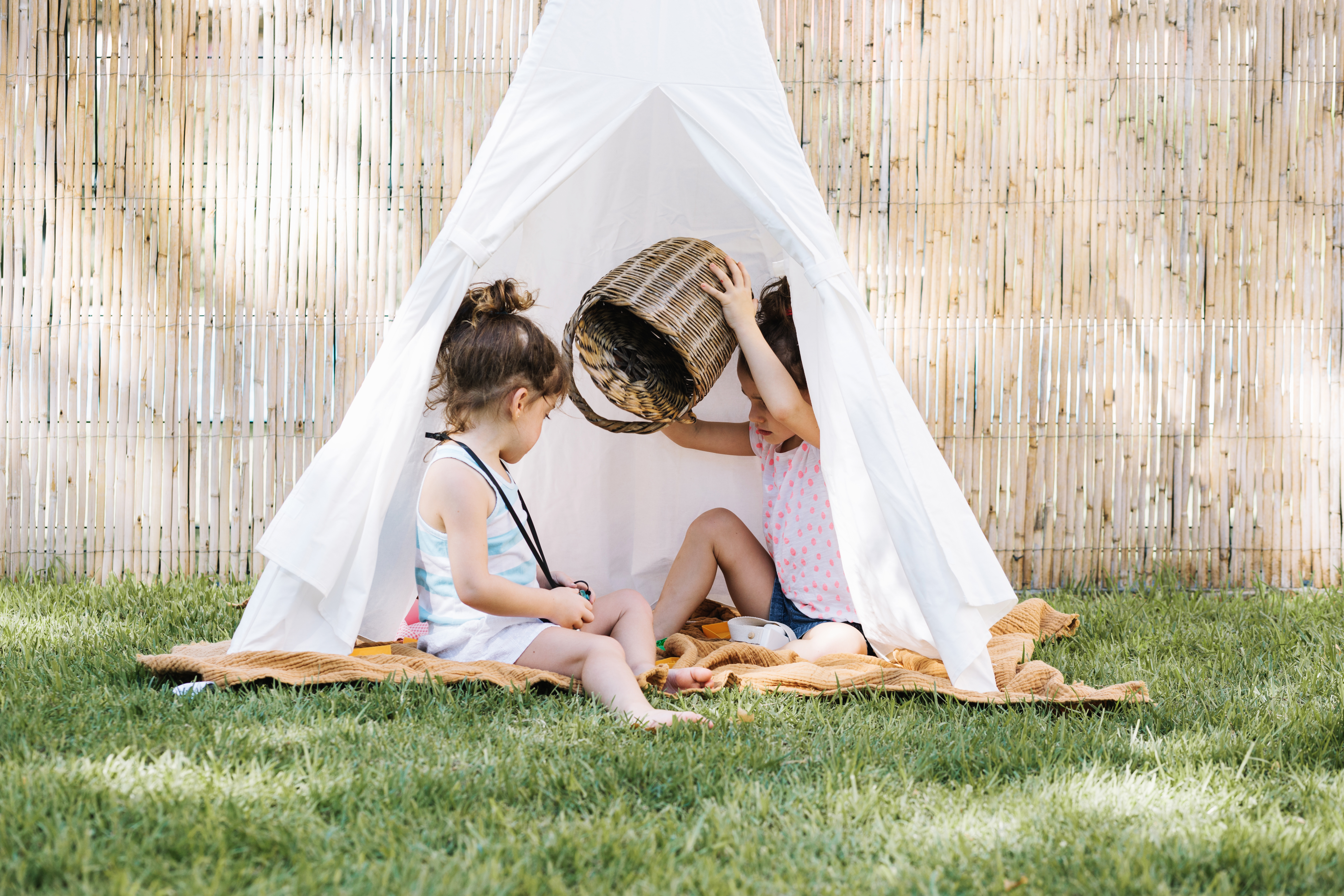 Niñas de 4 años construyendo una guarida en su jardín