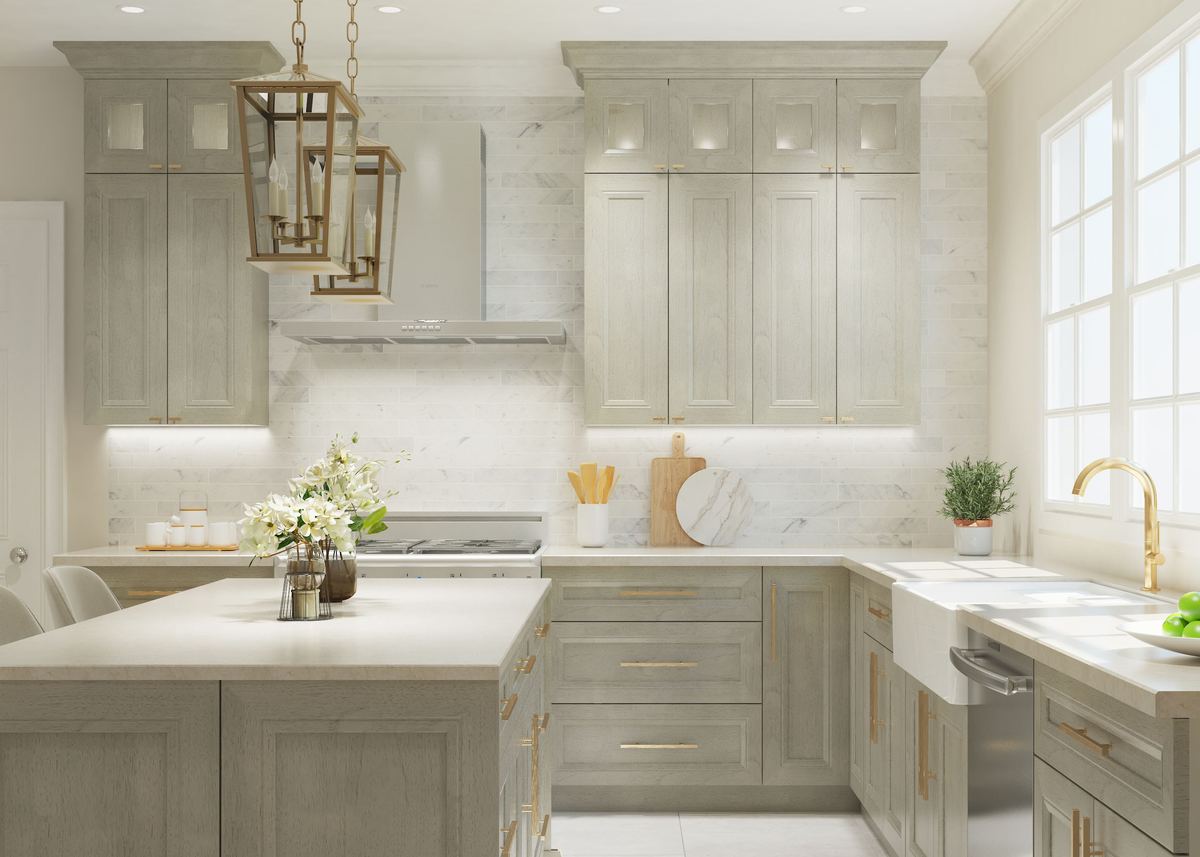 Light stone-colored kitchen with glass-front upper cabinets and brass lantern pendants