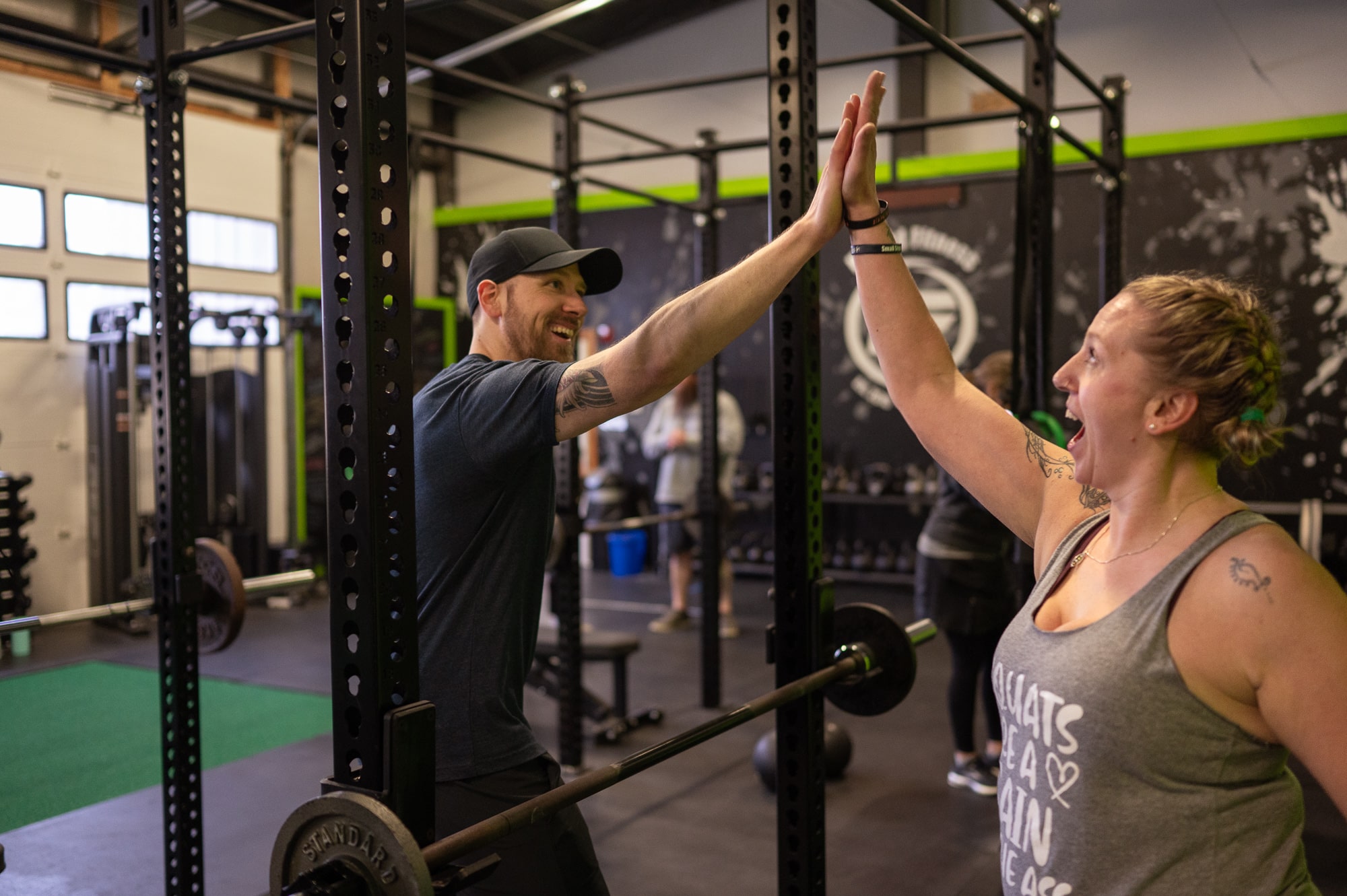 Hybrid Fitness coach high-fiving a member after a lift