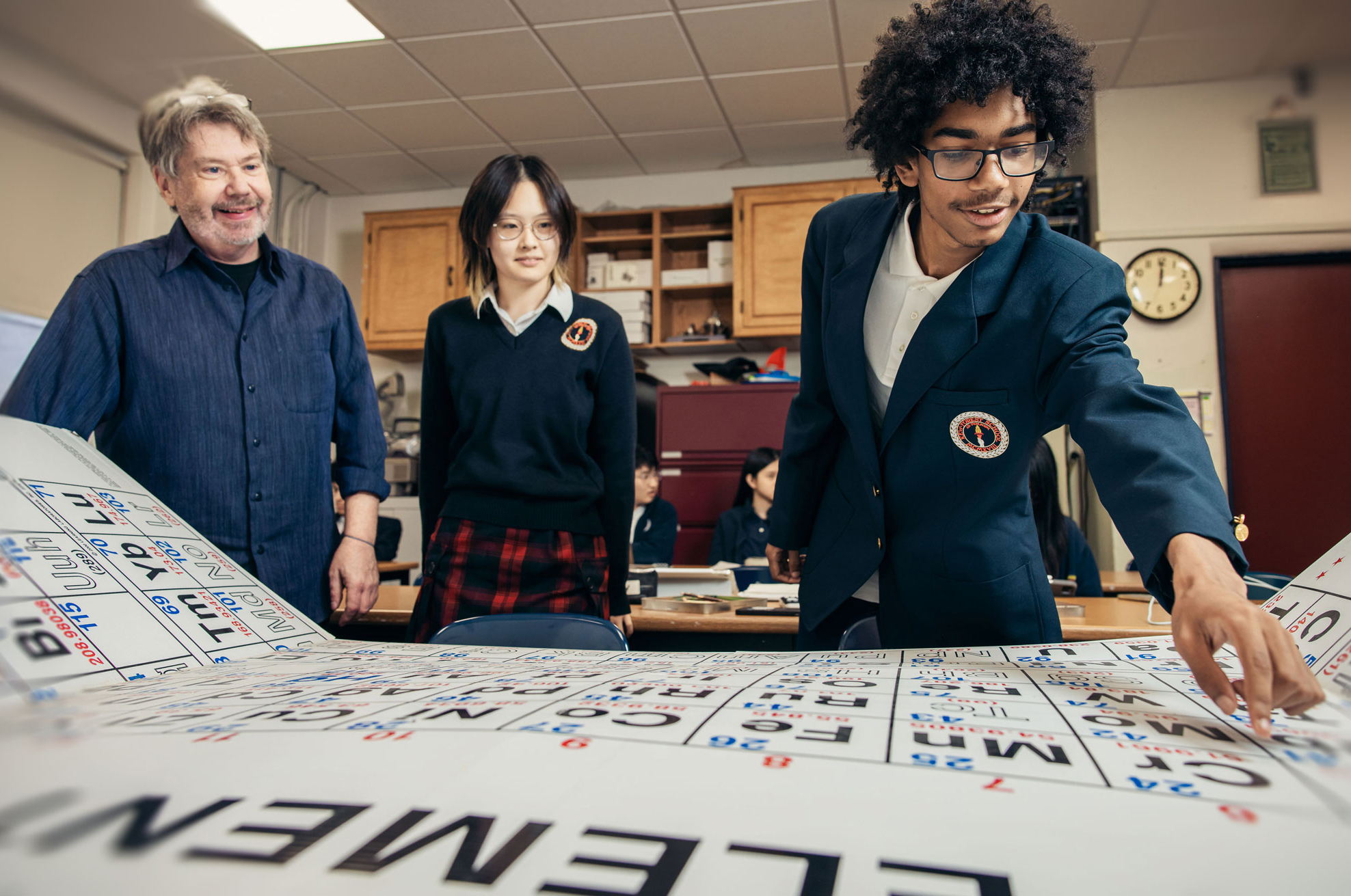 Students and teacher exploring the periodic table