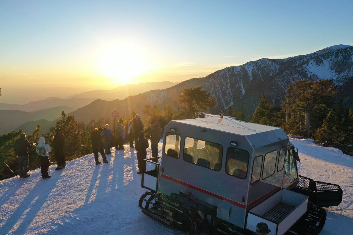 A snowcat tour on Mt Baldy seen from the air at sunset