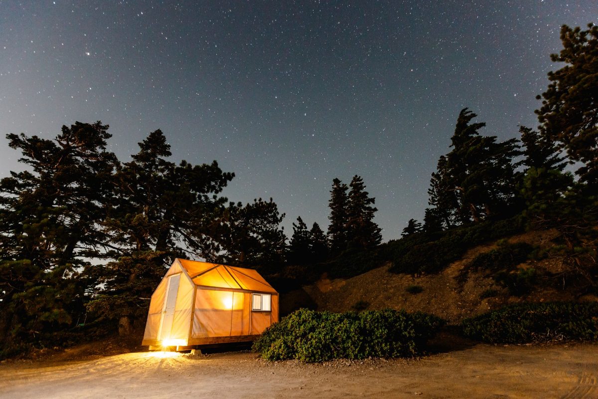 A Camp Baldy tent cabin glowing at night
