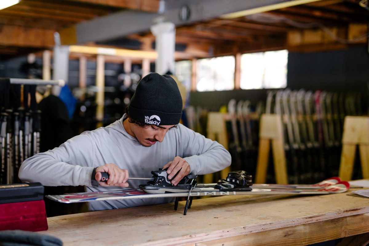 A tech tuning a ski in the Mt Baldy rental shop
