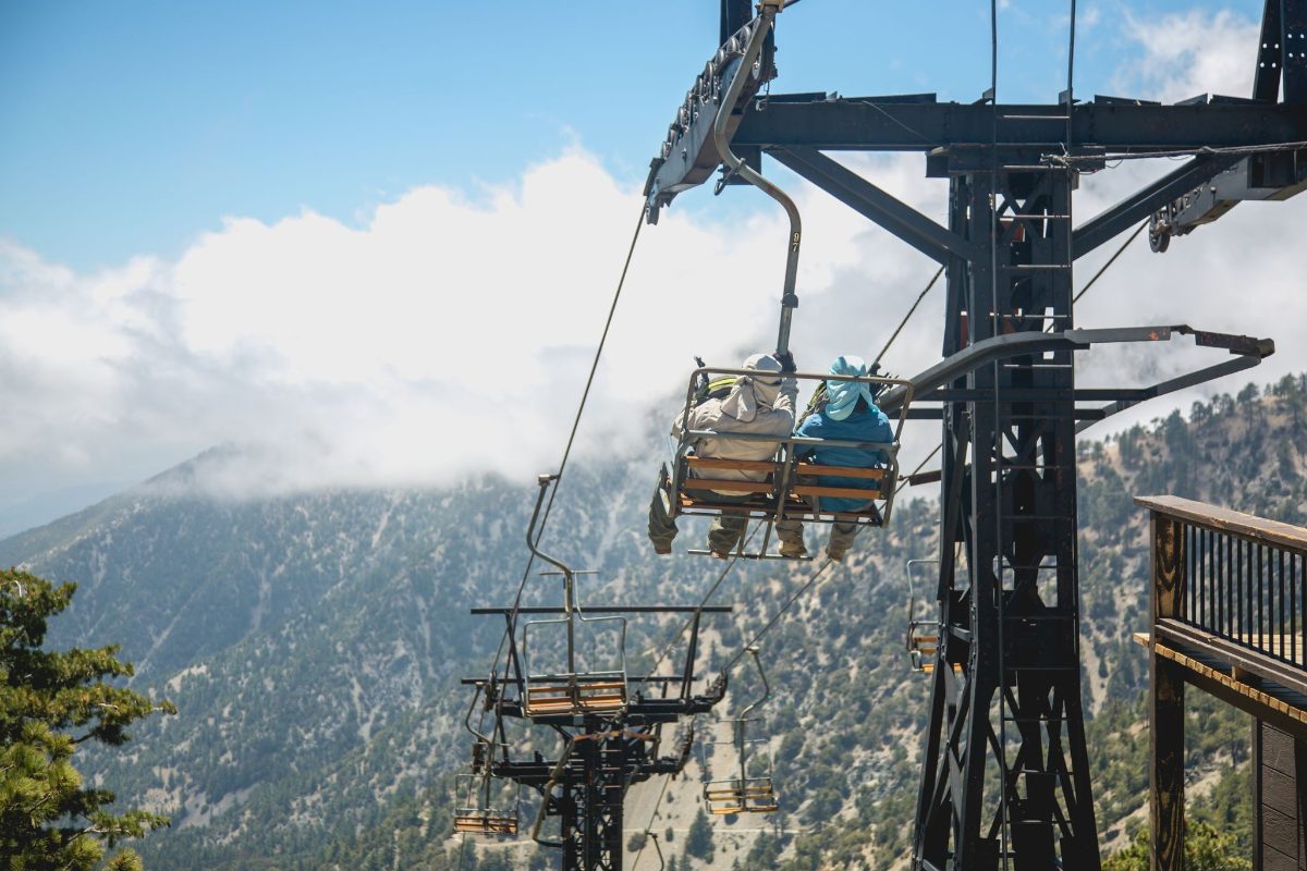 A chairlift tower and chairs on a summer day