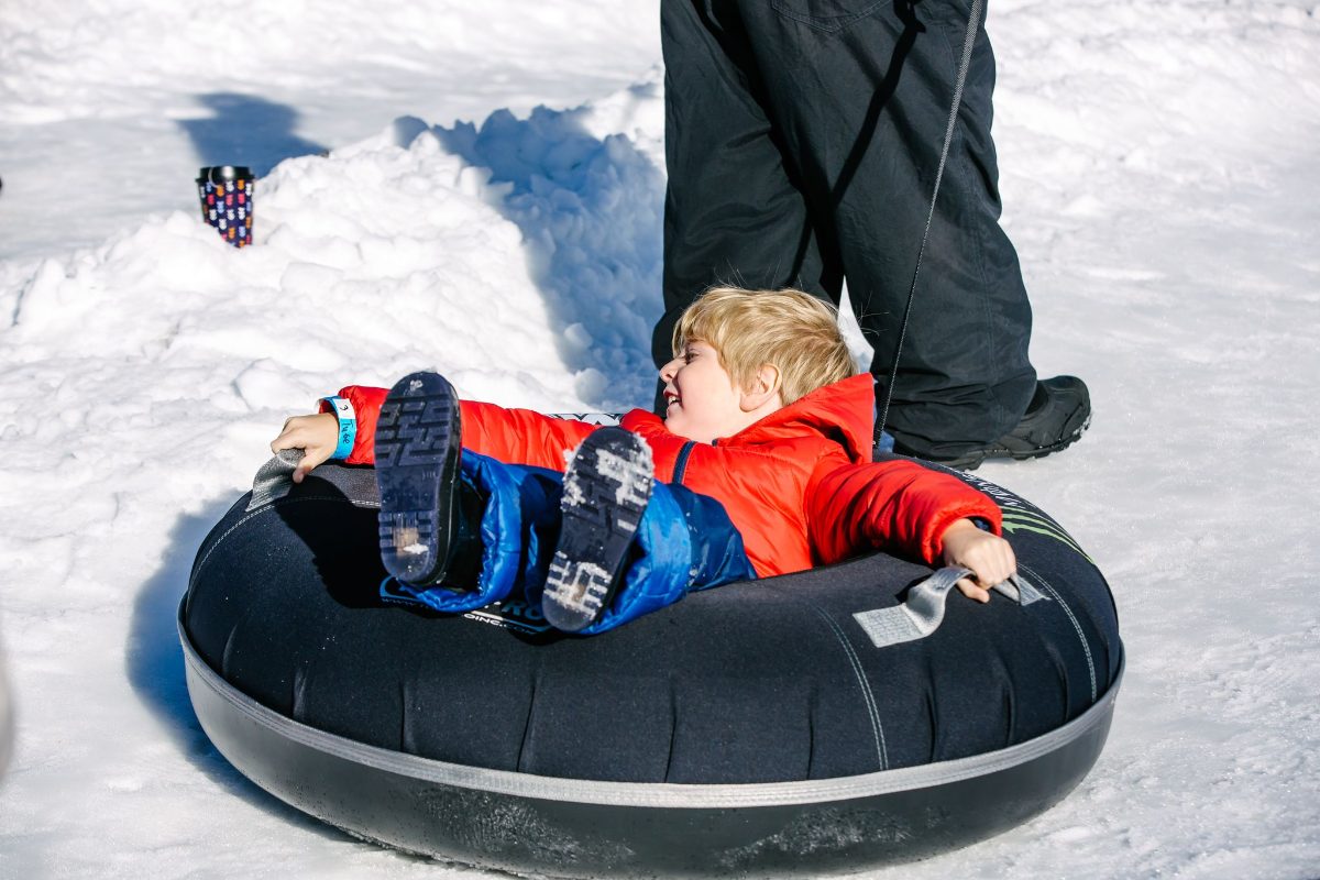 A kid riding a snow tube