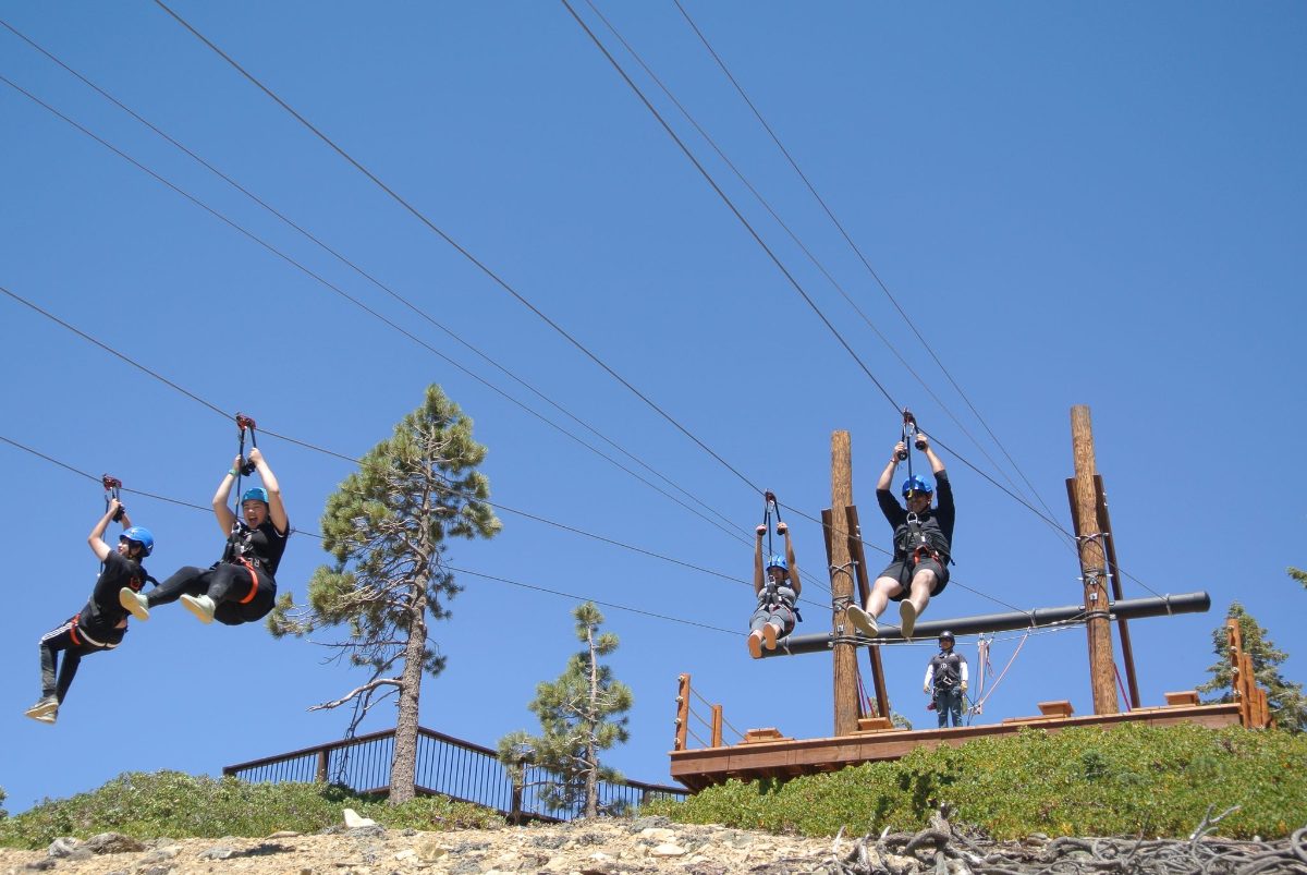 Zip line riders above the launch platform