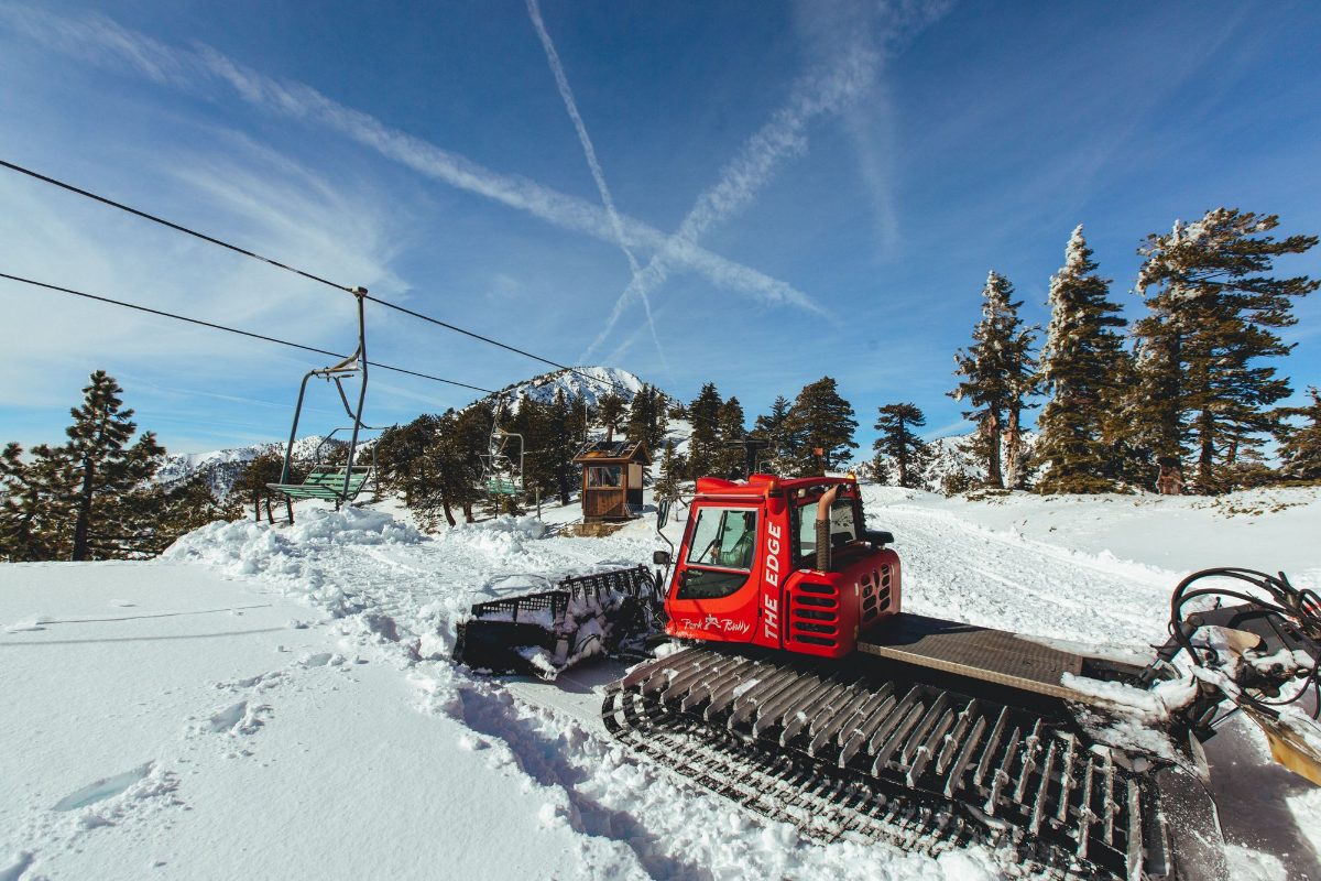 A snowcat grooming on a bluebird day