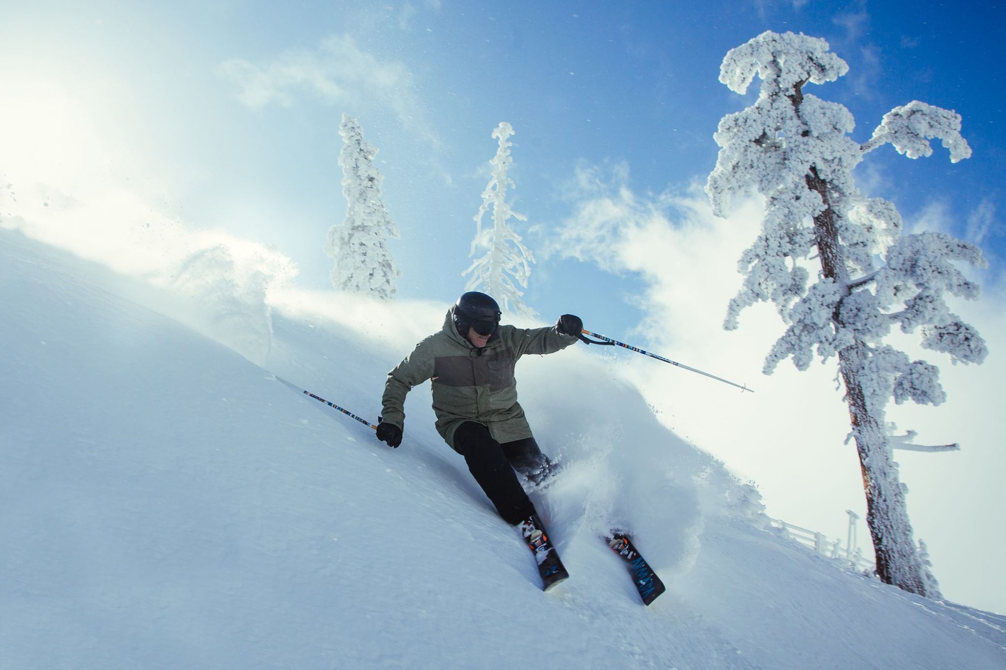 A skier in deep powder among frosted trees