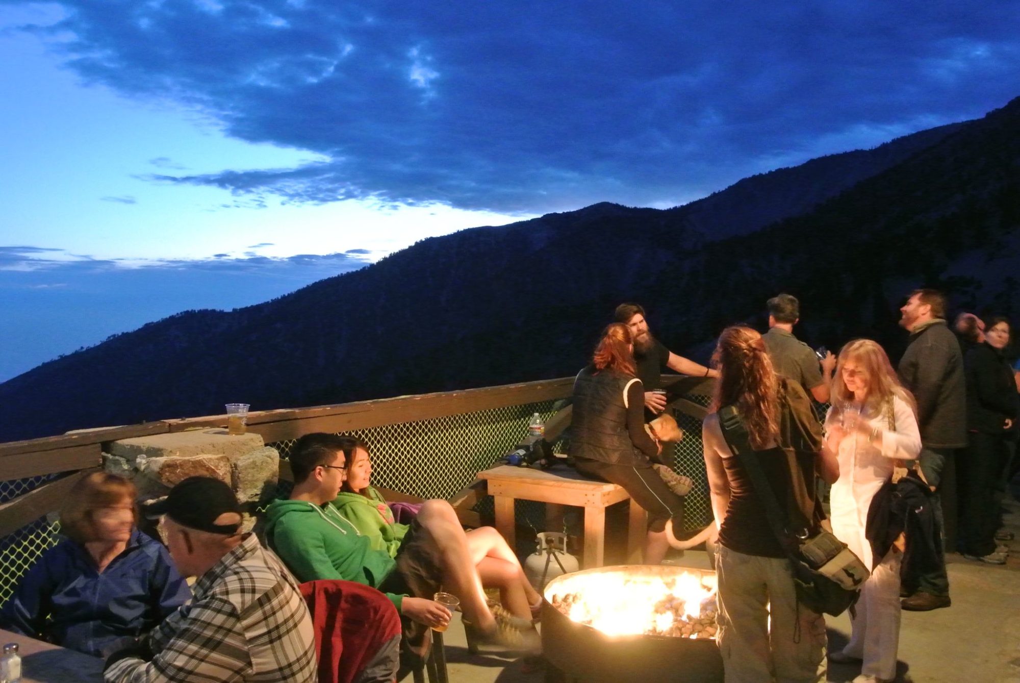 Guests around a fire pit on the Notch deck at night