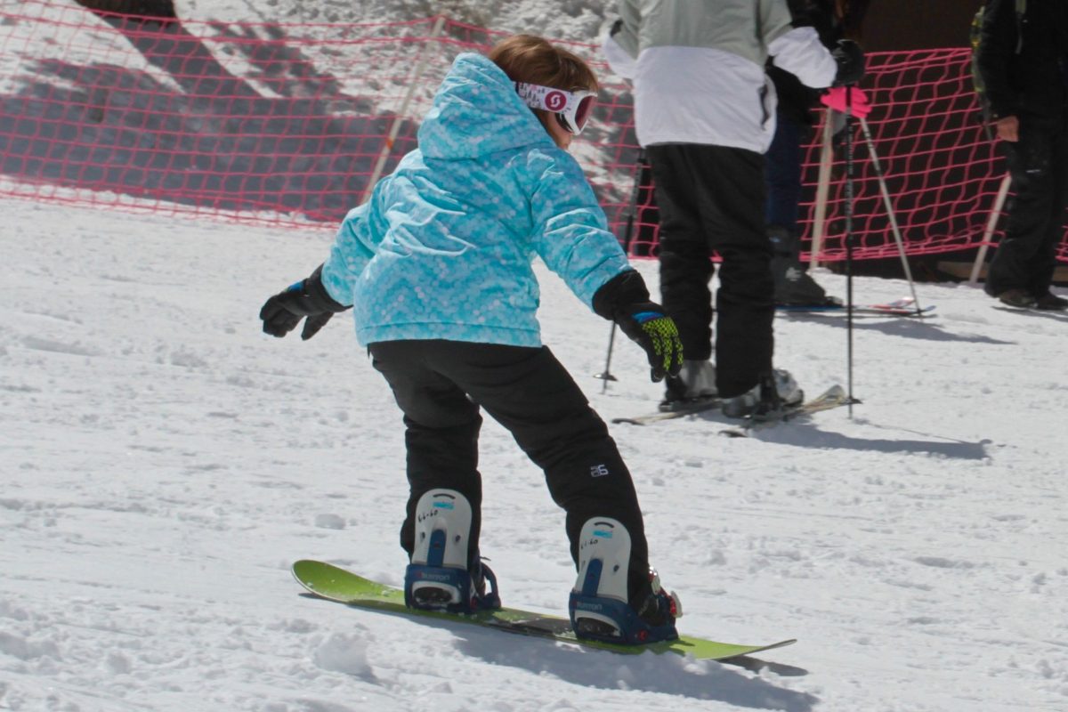 An instructor leading a snowboard lesson