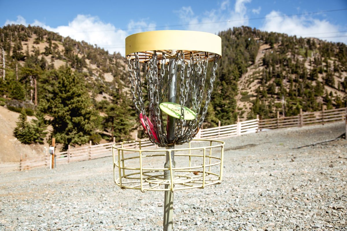 A disc golf basket with a mountain view