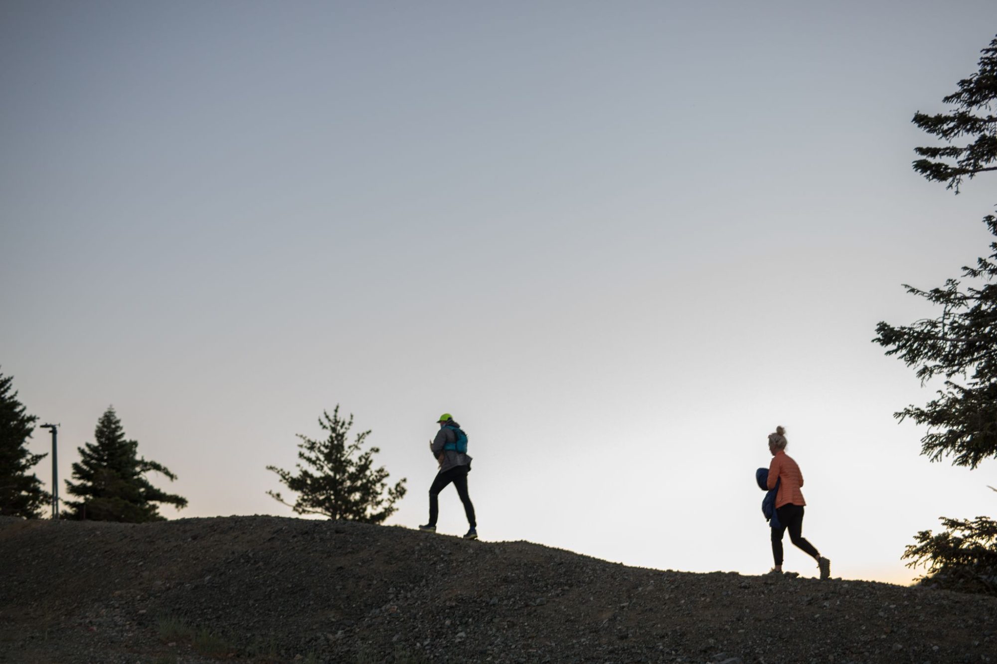 Hikers silhouetted on the ridge at dusk