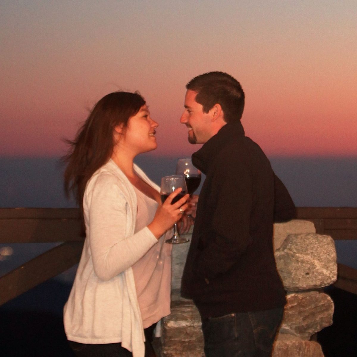 A couple toasting at sunset