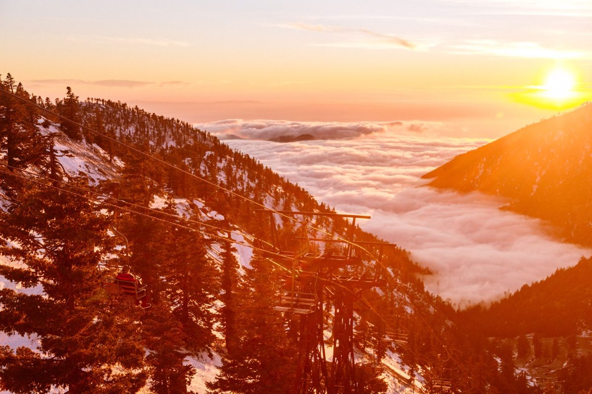 A red sunset over the clouds and snowy trees