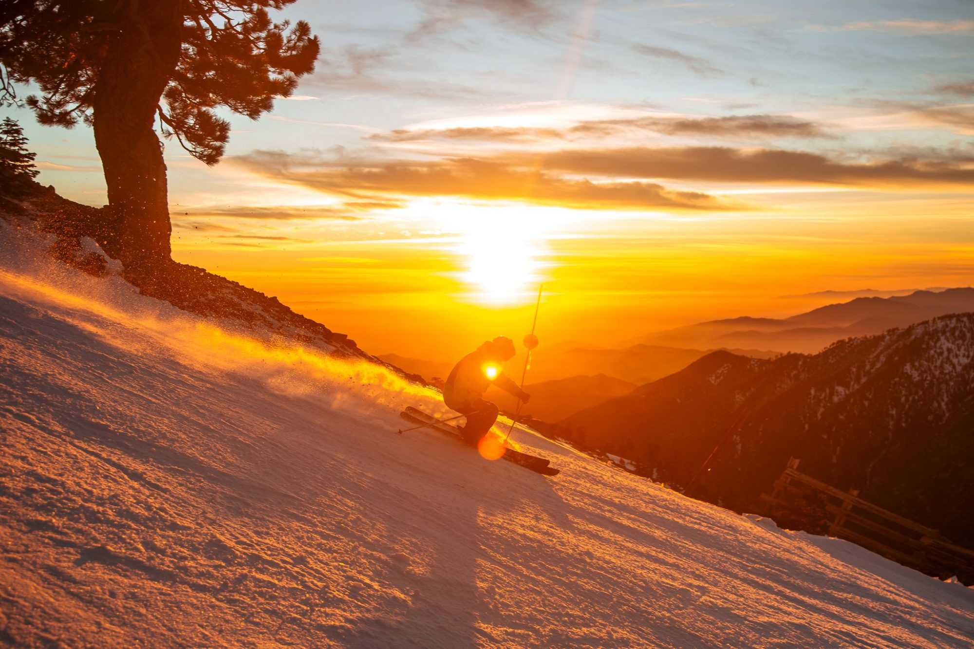 A skier spraying snow at sunset