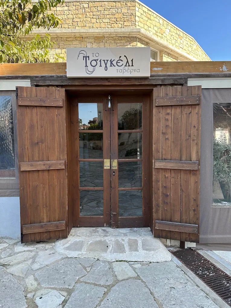 Η είσοδος με την πέτρινη πρόσοψη και την πινακίδα