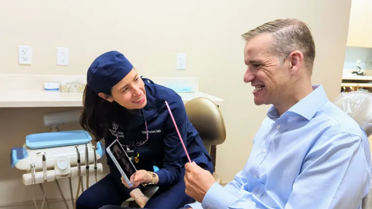 A patient seeing his new smile in the mirror with Dr. Furman