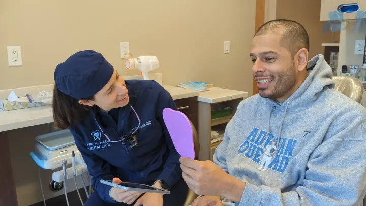 A patient checking his new smile in the mirror