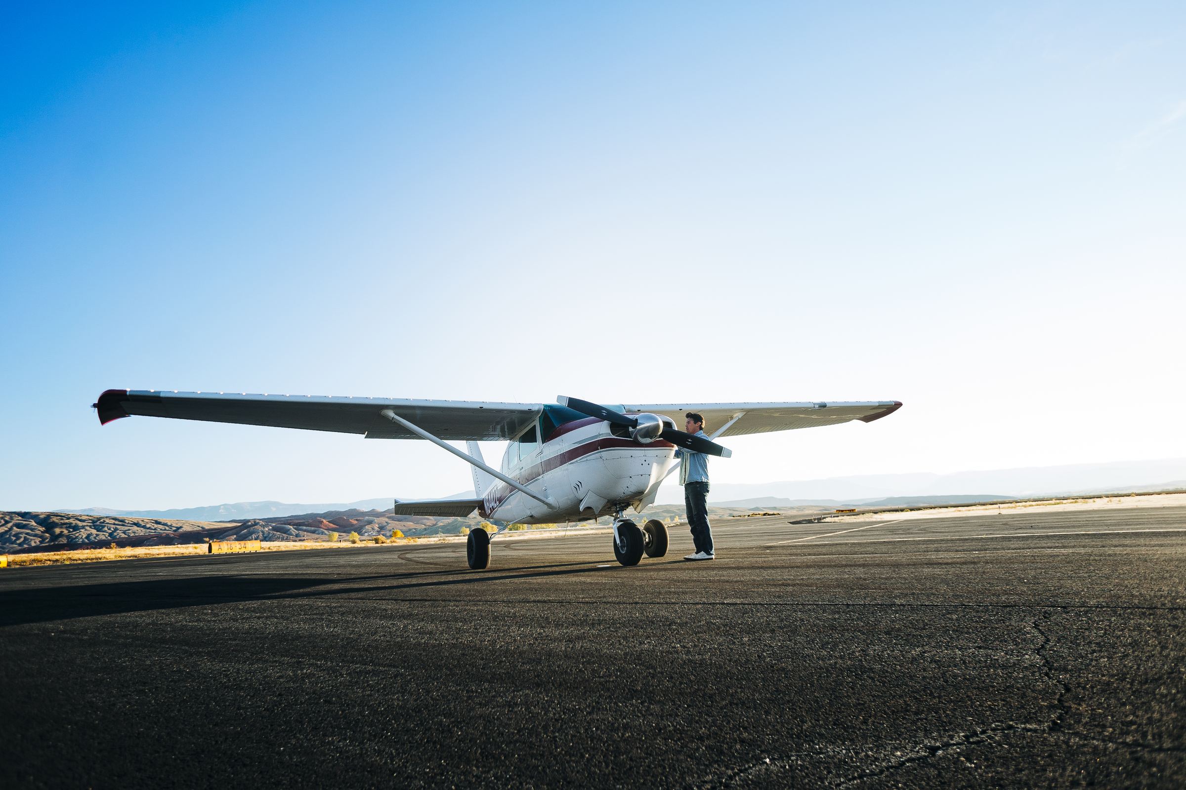 Bo Grant standing by the nose of his plane on the runway