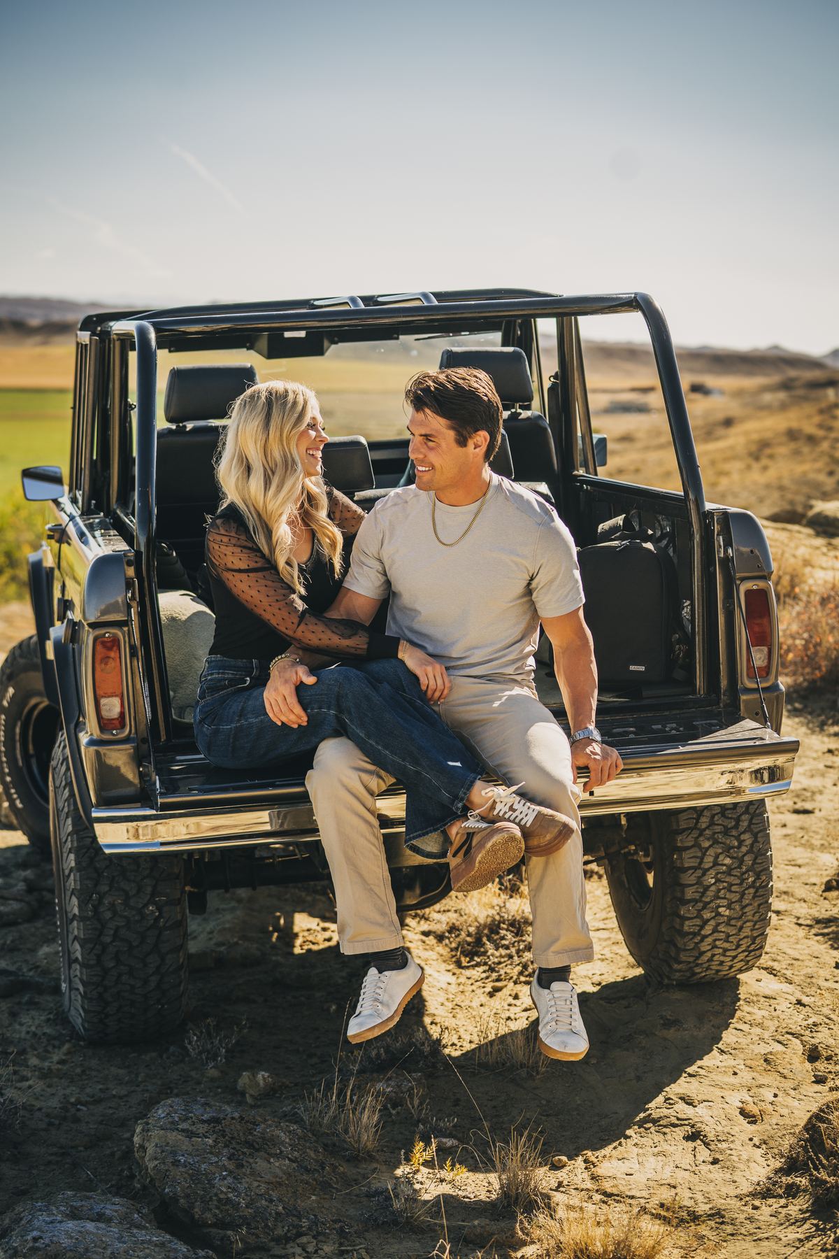 Bo Grant sitting in the back of a vintage 4x4 with his wife, McKinzea