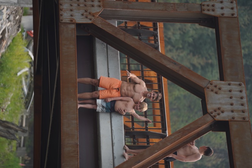 Bo Grant standing on a bridge over the river with his son