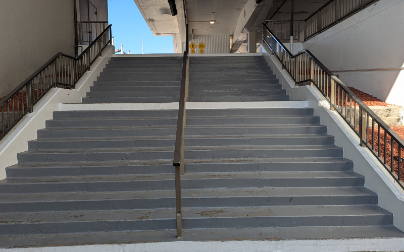Wide gray staircase leading upward toward an open sky, symbolizing the courage to move beyond fear.