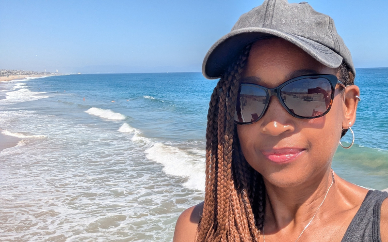 Leslie Sims Palmore standing beside the ocean, reflecting trust and peace while facing the unknown.
