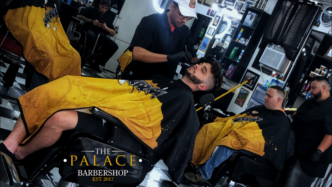 Barber giving a professional haircut at The Palace Barbershop in Rensselaer, NY
